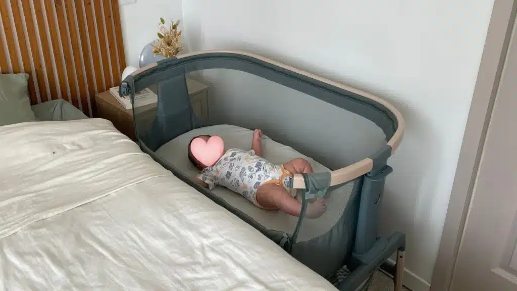 Lit cododo Maxi-Cosi Iora Air installé à côté du lit des parents avec bébé allongé.