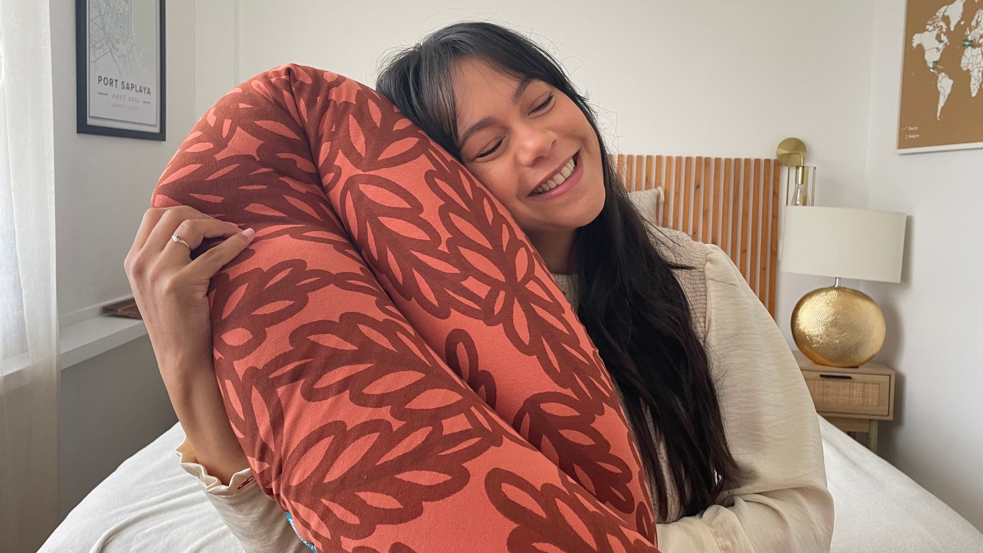 Femme enceinte allongée avec un coussin de grossesse pour soulager son dos et son ventre