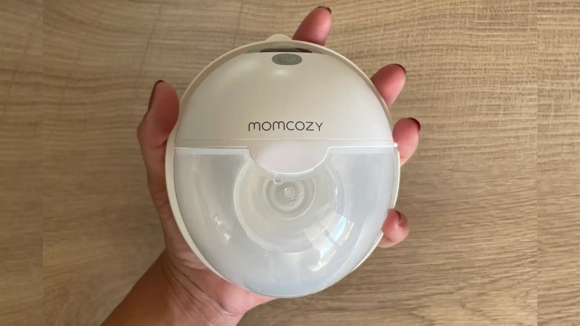Tire-lait Momcozy M5 tenu dans une main pour montrer sa taille
